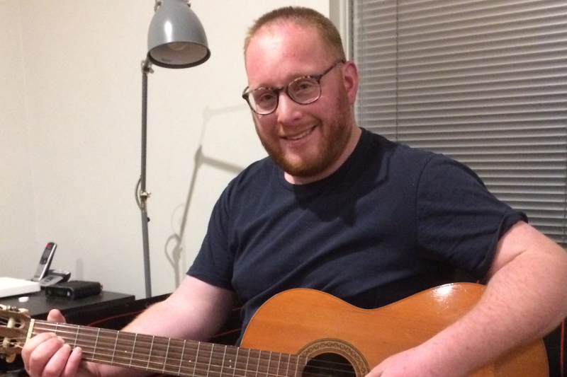 David Schenkel at home playing his guitar