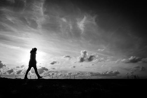 Silhouette of sole person walking alone.