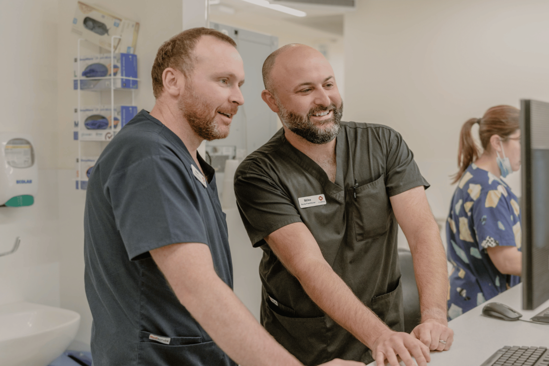 Two male nurses at PC, one training the other